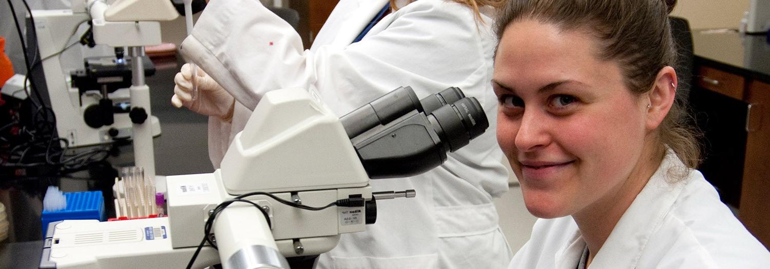 Young lady in front of a microscope